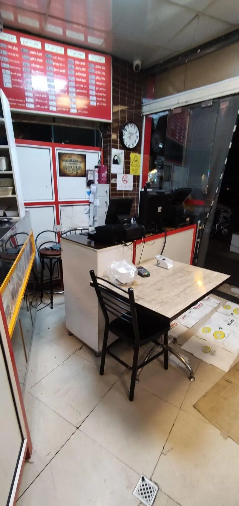 نمای داخلی رستوران فست فود پیتزا تک: پیشخوان سفارش، منوی جذاب روی تابلو، میز غذاخوری برای مشتریان و محیطی دلنشین و آماده خدمت.