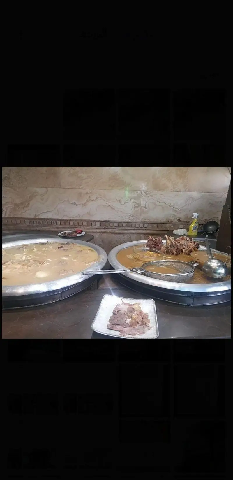 تصویری از دو قابلمه بزرگ کله پاچه داغ و تازه در طباخی قوچ، میشک، آماده سرو، با بشقابی از گوشت لذیذ در پیش‌زمینه.