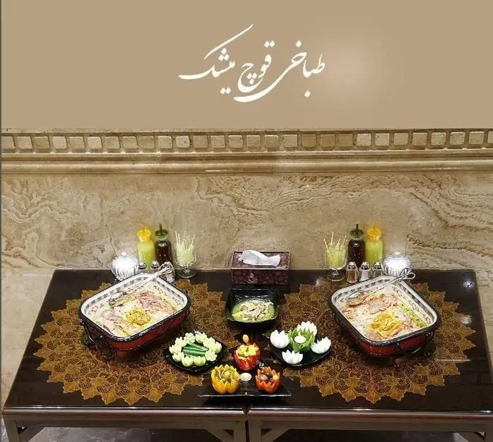 میز غذای مجلل طباخی قوچ میشک با دو ظرف بزرگ آش یا حلیم، چیدمان زیبا و مخلفات کامل، مناسب برای میزبانی. لذت غذای سنتی ایرانی.