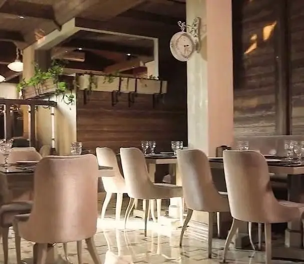 فضای داخلی دلنشین و دکوراسیون شیک رستوران هفت با صندلی‌های راحت و میزهای چیده شده، ایده‌آل برای تجربه یک وعده غذایی لذت‌بخش.