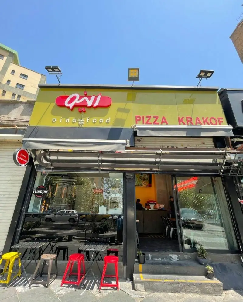 تصویر نمای خارجی فست فود اُينو، عرضه کننده پیتزا کراکف و انواع ساندویچ، با تابلوی مشخص و میز و صندلی‌های جذاب برای مشتریان.