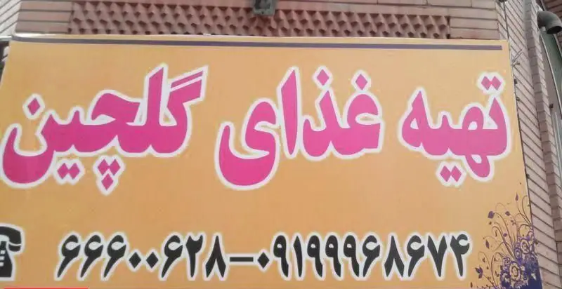 تصویر تابلوی تهیه غذای گلچین با فونت درشت و رنگ‌های صورتی و نارنجی، شامل نام و شماره تماس برای سفارشات غذایی و کترینگ در شهر.