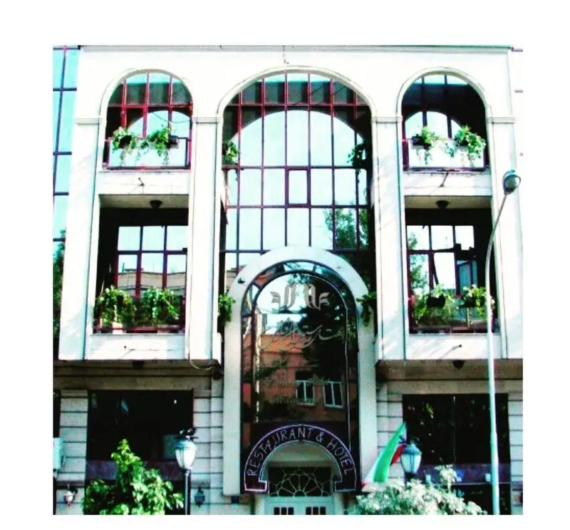 نمای بیرونی رستوران و هتل قناری با معماری کلاسیک، ورودی قوسی و پنجره‌های بزرگ. مکانی دلپذیر برای صرف غذا و اقامت.