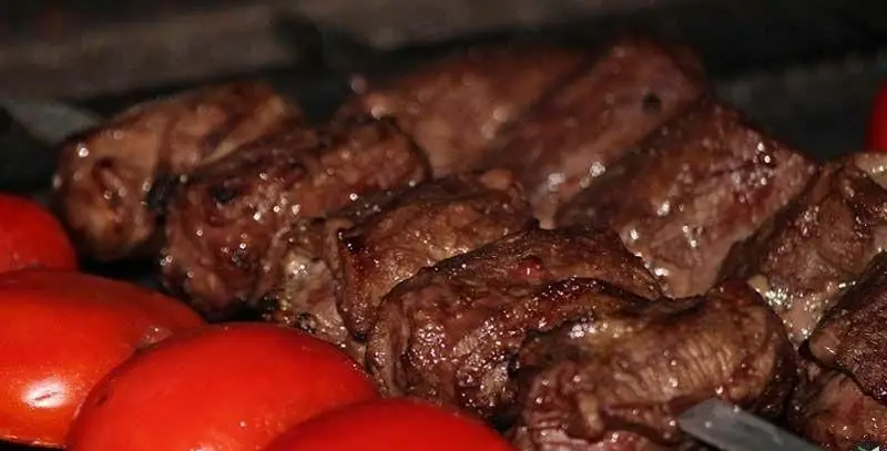 کباب داغ و خوش‌طعم کبابی ساحل، همراه با تکه‌های گوشت تازه و آبدار روی منقل و گوجه‌های سرخ و لذیذ، بهترین غذای ایرانی