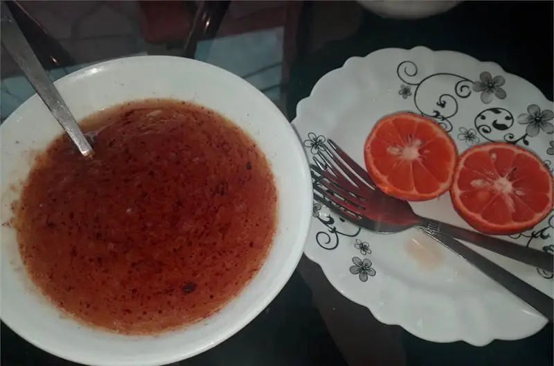 آبگوشت کله‌پاچه تازه و لذیذ طباخی توچال در کاسه‌ای سفید، همراه با لیموترش‌های برش‌خورده روی بشقاب. غذای سنتی باکیفیت برای صبحانه.