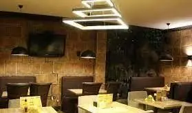 نمای داخلی شیک و مدرن رستوران آروما با دکوراسیون آجری، میز و صندلی‌های راحت و نورپردازی خاص برای تجربه غذایی دلپذیر.