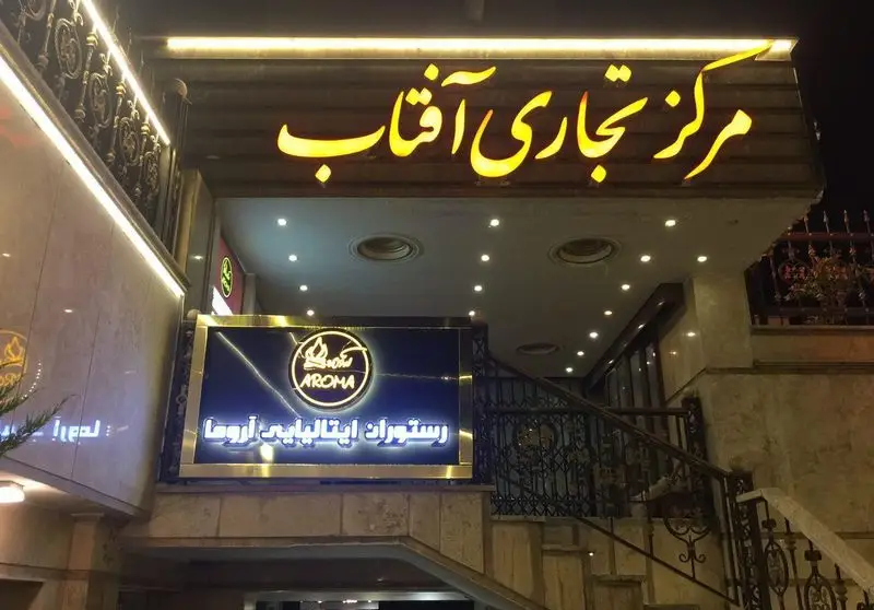 تصویر تابلوی روشن ورودی رستوران ایتالیایی آروما در مرکز تجاری آفتاب با نمای شب و نورپردازی جذاب.
