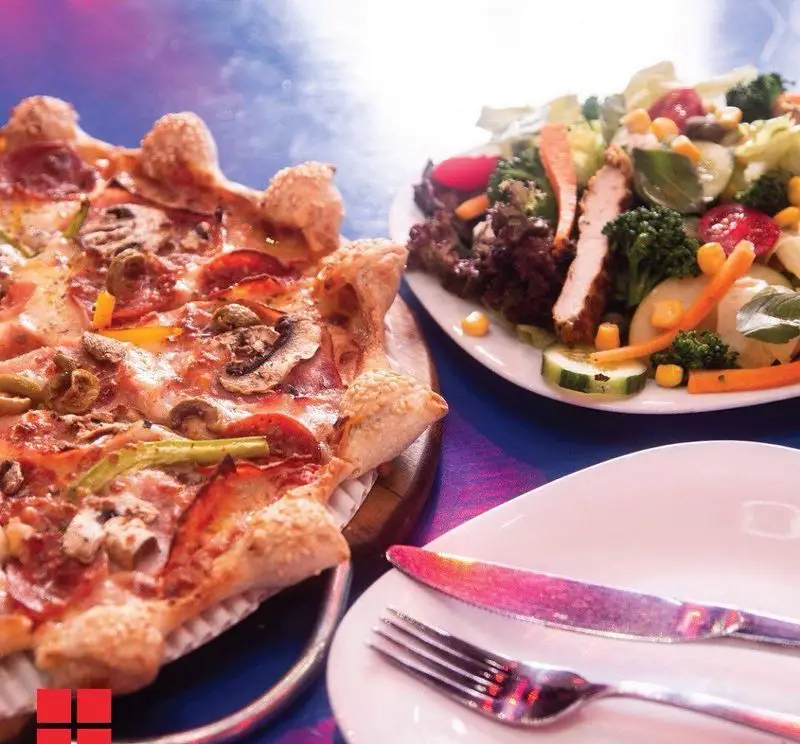 پیتزا پپرونی و قارچ با نان کنجدی خاص در کنار سالاد مرغ گریل و سبزیجات تازه، منوی جذاب و خوشمزه رستوران پیتزا نایت.
