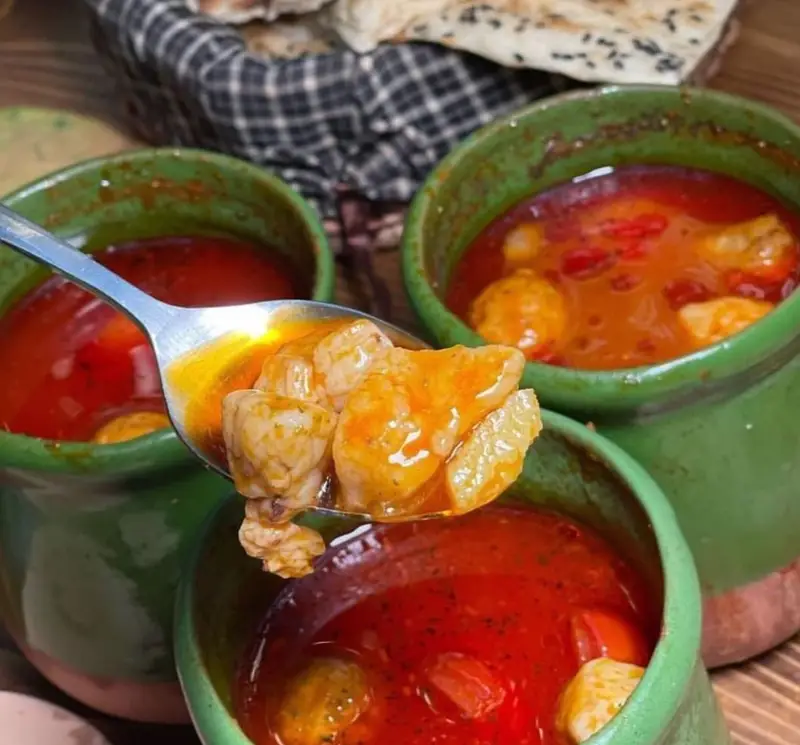 دیزی آبگوشت اصیل و لذیذ رستوران دیزی دیدار در ظروف سفالی سبز، با گوشت پخته و آب و نان سنگک، آماده سرو برای مشتریان گرامی.