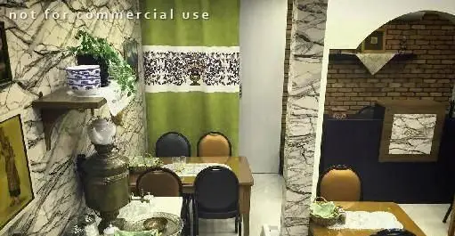 فضای داخلی دنج و سنتی رستوران ایرانی فرمان با دیوارهای مرمری، پرده سبز طرح‌دار، میز و صندلی. محیطی دلنشین برای صرف غذای اصیل ایرانی.