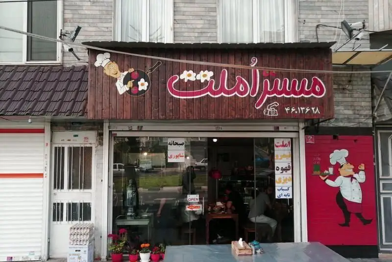 نمای بیرونی کافه و رستوران مستر املت، با تابلوی چوبی، آشپز کارتونی و تخم‌مرغ. ارائه دهنده املت، صبحانه و غذای ایرانی مانند دیزی و کباب.