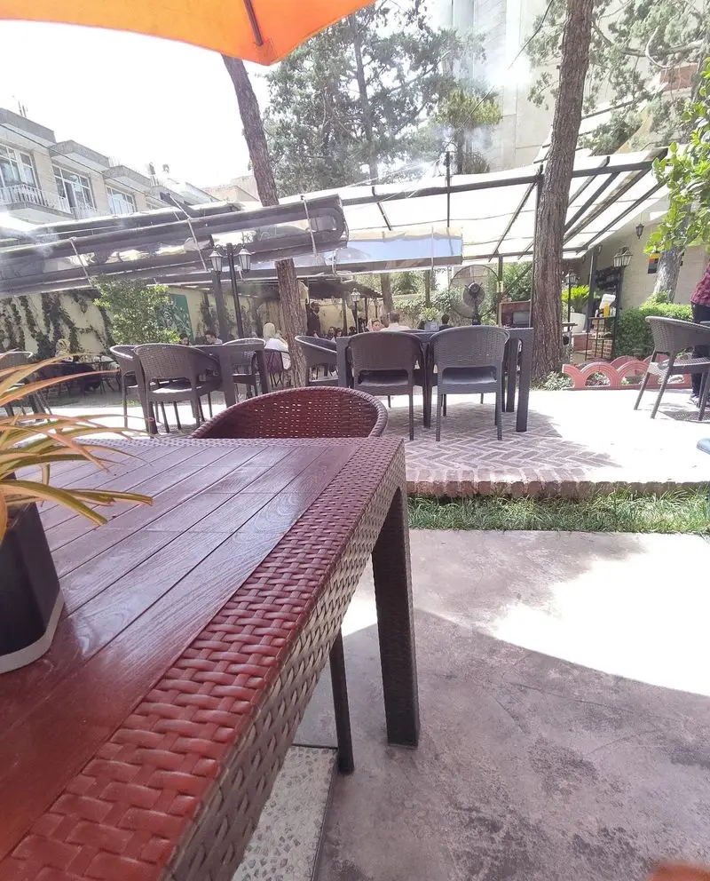 کافه هومان، مکانی آرام و دلپذیر با فضای باز و سایبان، میز و صندلی‌های راحت، تجربه‌ای لذت‌بخش از نوشیدنی‌ها در کنار دوستان.