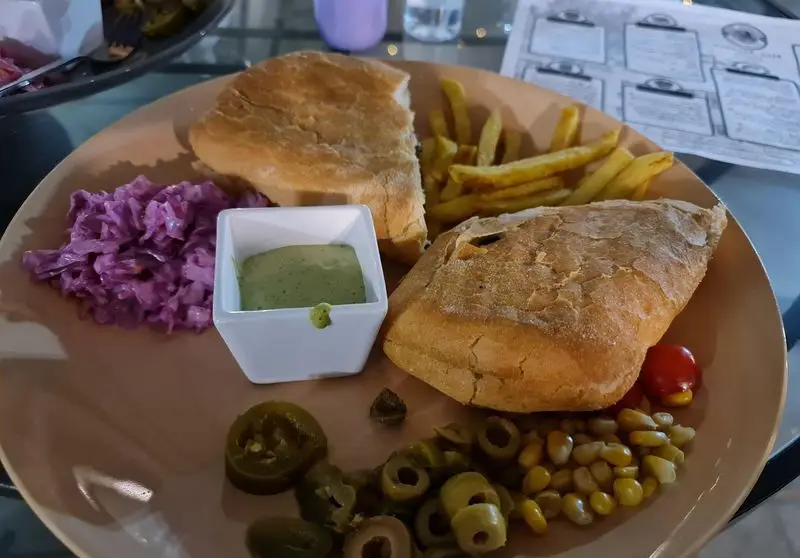 بشقاب کامل کافه هومان شامل نان تازه، سیب‌زمینی سرخ‌کرده، سالاد کلم بنفش، دیپ سبز، زیتون، ذرت و گوجه.