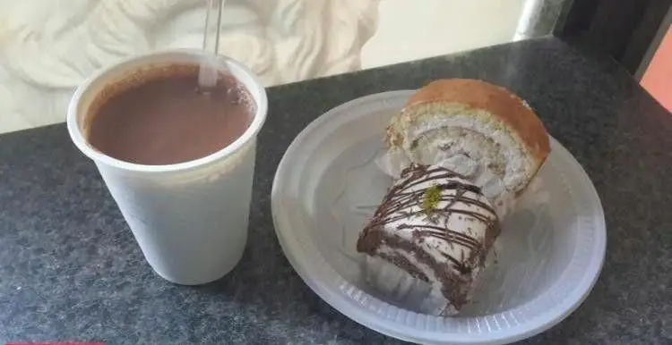 کیک و دسر خوشمزه قنادی ابوریحان شامل رولت خامه و کیک شکلاتی به همراه نوشیدنی گرم، تجربه‌ای شیرین.