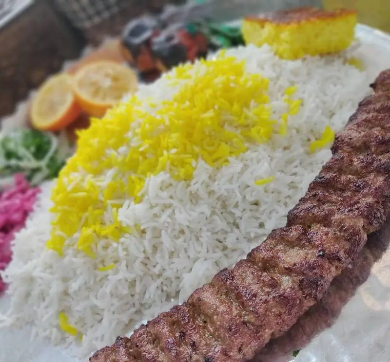 یک پرس چلو کباب کوبیده سنتی لذیذ از مازالو با برنج ایرانی، زعفران، ته دیگ طلایی و دورچین تازه. تجربه غذای اصیل ایرانی.