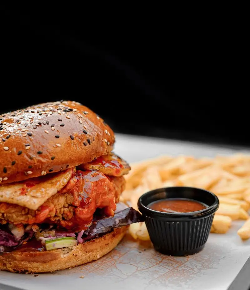برگر مرغ سوخاری مجلل کافه رستوران لوکی با نان کنجدی، پنیر آب شده، سس ویژه و سیب زمینی طلایی سرخ کرده، یک انتخاب عالی.