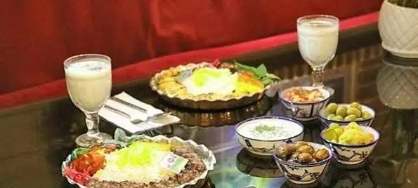 سفره‌ای دلپذیر از غذاهای سنتی ایرانی: چلوکباب، برنج زعفرانی، دوغ خنک و مخلفات خوشمزه در کافی شاپ دلنوازان.