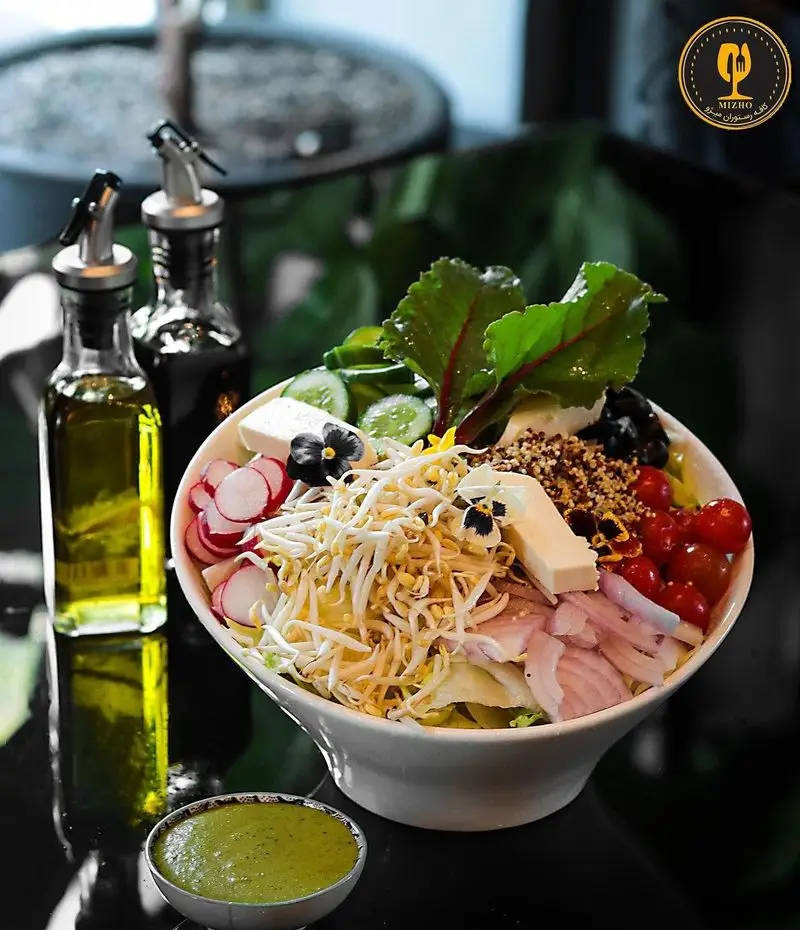 سالاد تازه و رنگارنگ کافه رستوران میژو شامل انواع سبزیجات، جوانه‌ها، پنیر، گوجه، خیار و سس مخصوص. مناسب غذای سالم.