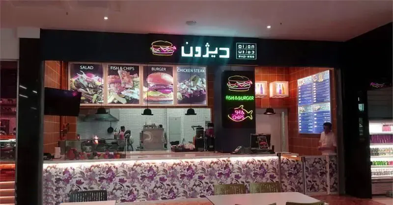 تصویری از نمای داخلی فست‌فود دیزون اکسپرس در مرکز خرید سانا. رستوران با منوی گسترده برگر، فیش اند چیپس، سالاد و چیکن استیک، آماده پذیرایی از مشتریان است.