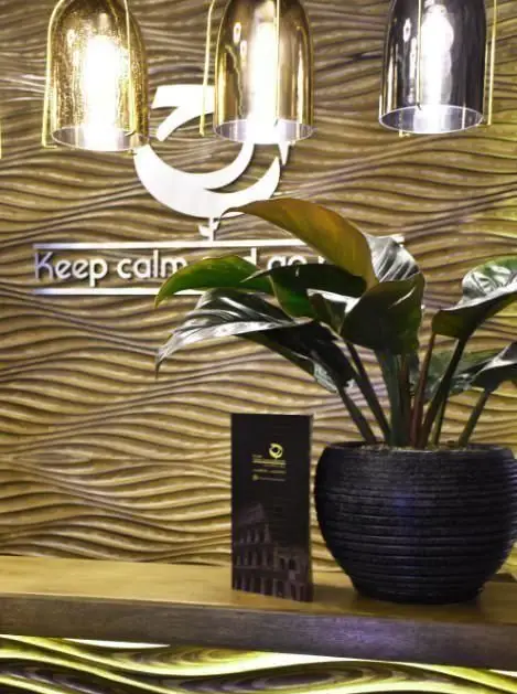 دکوراسیون داخلی جذاب و مدرن رستوران هیراد، با لوسترهای طلایی، دیوارپوش موج‌دار چوبی و گلدان طبیعی، فضایی آرام برای تجربه غذا.