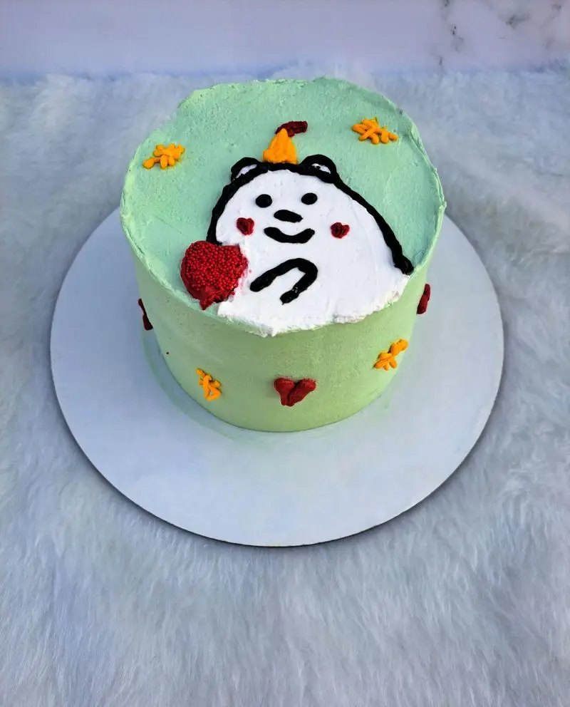 کیک تولد سبز لونا کیک با طراحی خرس کارتونی سفید، کلاه جشن و قلب قرمز. کیک سفارشی فانتزی با دیزاین برگ و قلب.