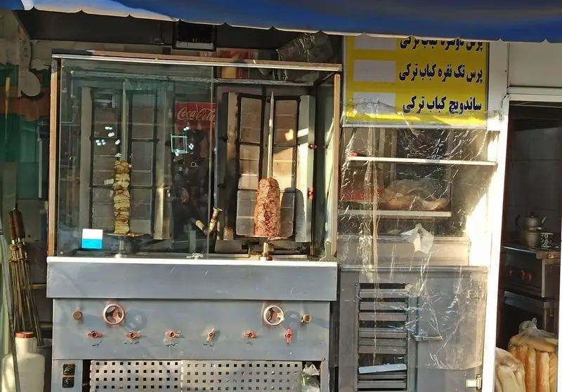 تصویری از دستگاه‌های دونر کباب مرغ و گوشت در فست فود ملوان، آماده سرو پرس و ساندویچ کباب ترکی تازه و لذیذ برای مشتریان.