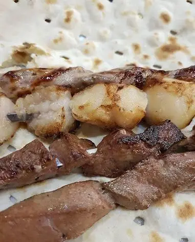 کباب جگر و دنبه ذغالی با نان تازه و سنتی در جگرکی پاتوق، تجربه غذایی لذت‌بخش از کباب‌های اصیل و لذیذ.