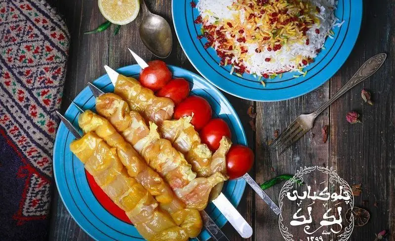 چلوکباب جوجه لذیذ رستوران و تهیه غذای لک لک: سیخ‌های جوجه کبابی و گوجه کبابی با برنج زعفرانی و زرشک، تزئین شده با لیمو.