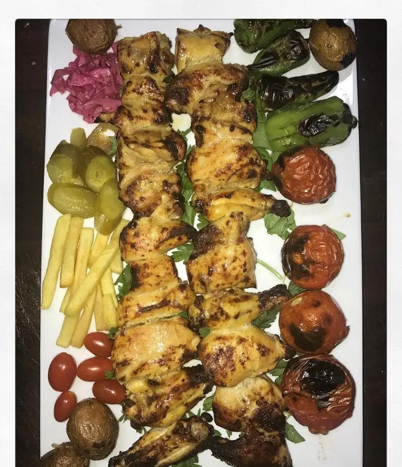 سینی لذیذ جوجه کباب با استخوان، گوجه، فلفل کبابی، سیب زمینی سرخ کرده، خیارشور و ترشی کلم قرمز از رستوران و تهیه غذای لک لک