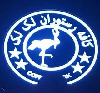 تصویر لوگوی نئونی آبی روشن رستوران و تهیه غذای لک لک با طرح فلامینگو در مرکز و ستاره‌های سفید، بهینه‌سازی شده برای سئو محلی.