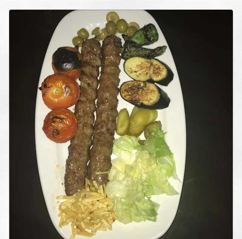 کباب کوبیده مخصوص و اصیل ایرانی از رستوران و تهیه غذای لک لک با گوجه، بادمجان کبابی، زیتون، خیارشور و سیب زمینی سرخ کرده.