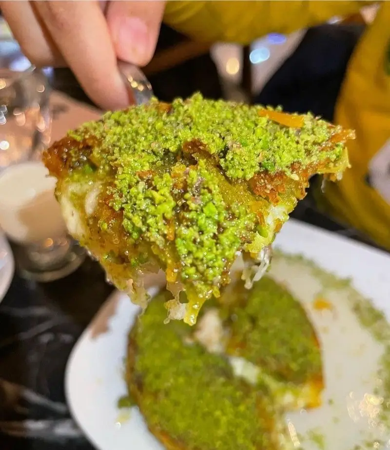 دسر کنافه پنیری داغ و شیرین با پسته فراوان از باقلوای ترکی علی کیپا پیروزی. طعم بی‌نظیر و اصیل شیرینی‌های سنتی ترکیه‌ای در تهران.