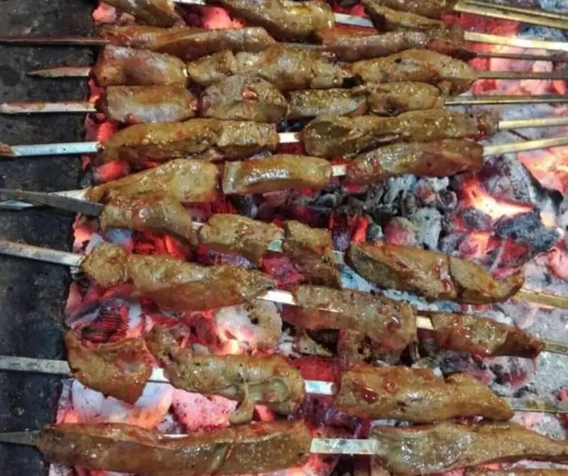 سیخ‌های جگر کبابی تازه و طعم‌دار در حال پخت روی حرارت زغال در جگرکی شاطر میرزا، انتخابی لذیذ.