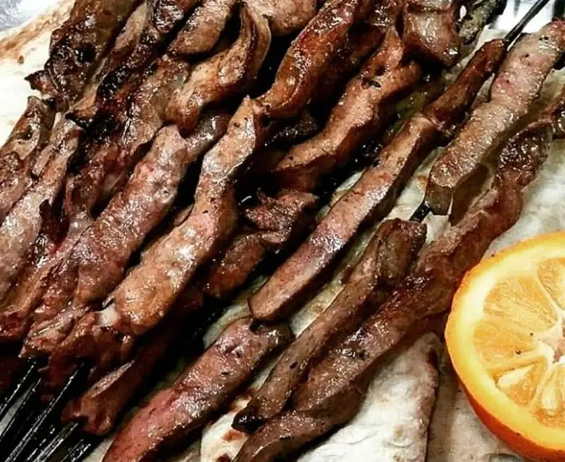 کباب جگر تازه و لذیذ از جگرکی کبابی شاطر میرزا، سیخ‌های جگر گوسفندی خوش‌طعم، روی نان داغ با برش لیمو/نارنج.
