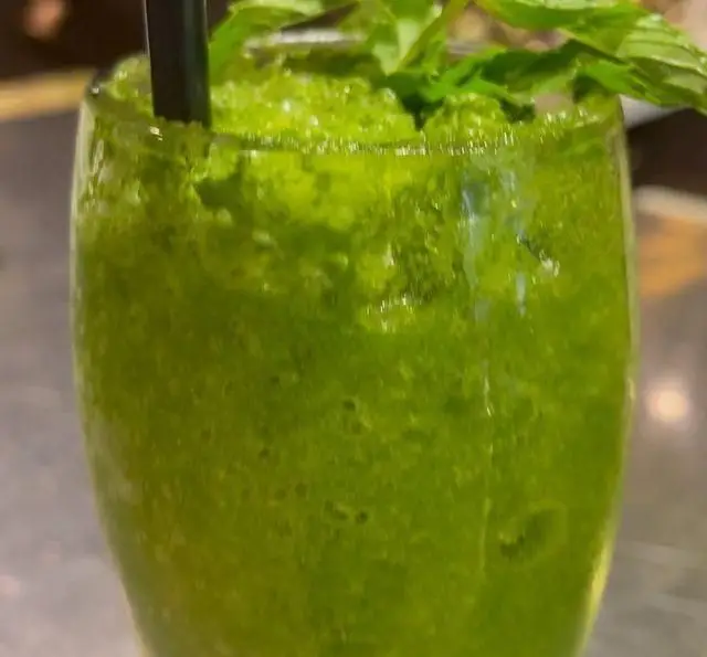 اسموتی سبز نعنایی و خنک کافه سیدمهدی، با برگ‌های تازه نعنا و نی مشکی. نوشیدنی گوارا و سالم، انتخابی ایده‌آل برای لذت شما.
