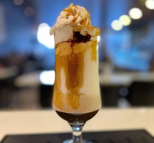 نوشیدنی لایه ای ویژه کافه سیدمهدی: یک دسر قهوه جذاب با خامه فرم گرفته، سس کارامل و لایه های قهوه و شیر، لذت بخش و دلپذیر.