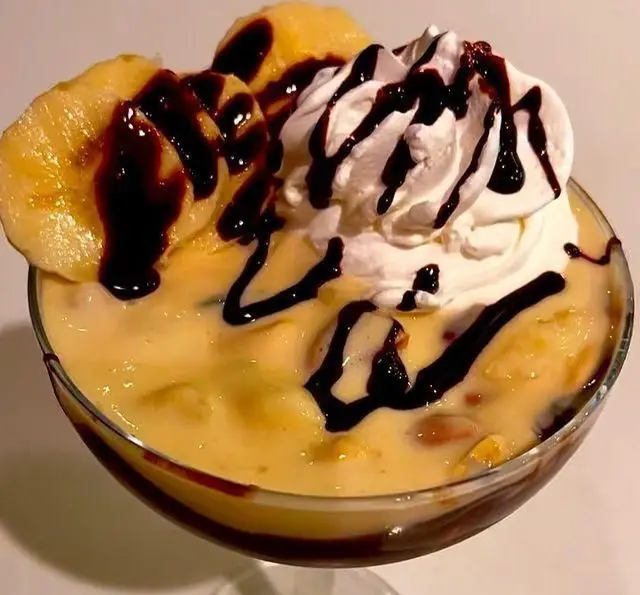 کافه سیدمهدی تقدیم می‌کند: دسر موز و شکلات خامه ای، ترکیبی دلنشین از پودینگ موز، تکه‌های موز تازه، خامه فرم‌گرفته و سس شکلات غلیظ. یک شیرینی بی‌نظیر!