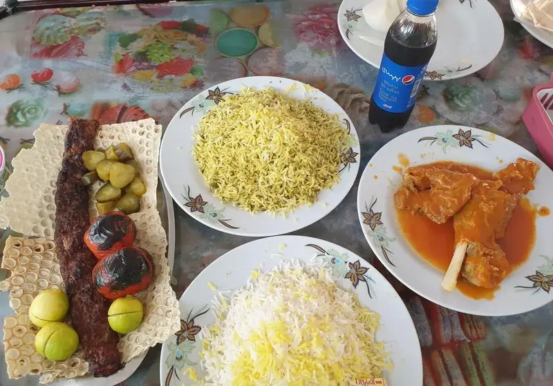 رستوران شاد: میز کامل غذای سنتی ایرانی شامل کباب کوبیده، برنج، ماهیچه، گوجه کبابی، ترشی و نوشابه. کیفیت عالی.