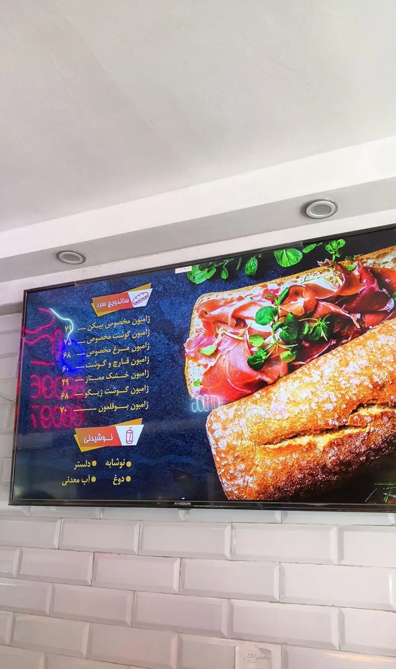 منوی ساندویچ هایدا: نمایشگر دیجیتال انواع ساندویچ سرد ژامبون بیکن، گوشت، مرغ و قارچ، به همراه نوشیدنی‌ها، قیمت‌ها و تصویر.