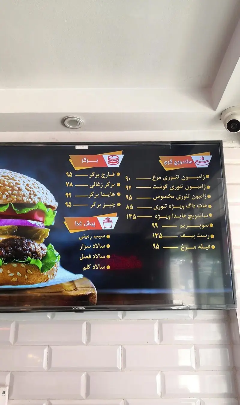 منوی دیجیتال ساندویچ هایدا شامل انواع برگر، ساندویچ گرم و پیش غذا با قیمت‌های به‌روز، همراه با تصویر یک برگر لذیذ.