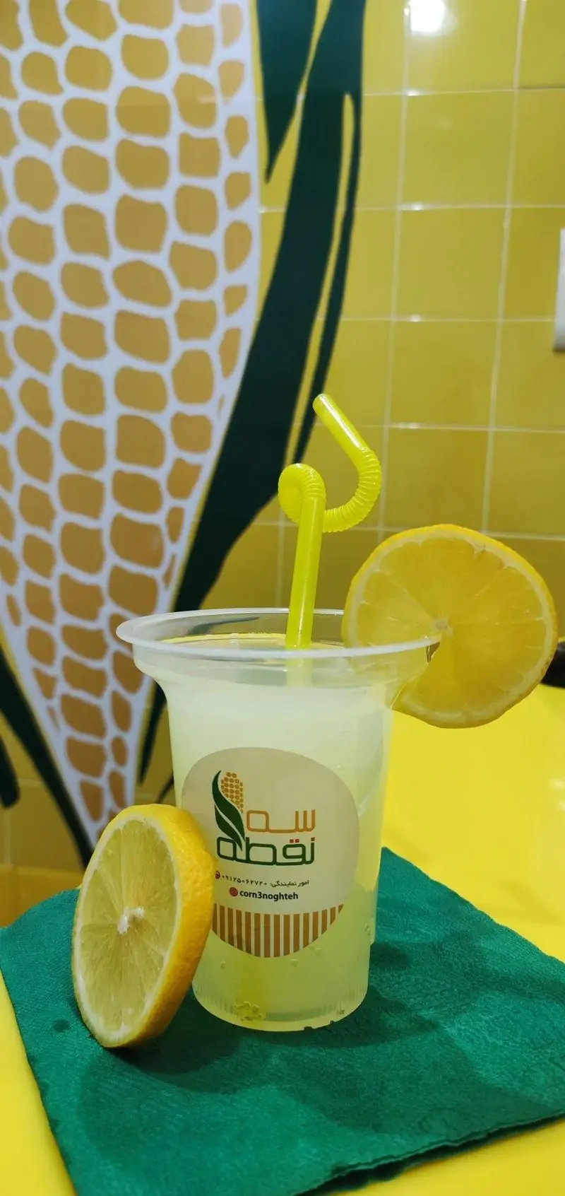 لیموناد تازه و خنک از "ذرت مکزیکی سه نقطه کارگر شمالی" با برش لیمو و لوگوی سه نقطه روی لیوان.