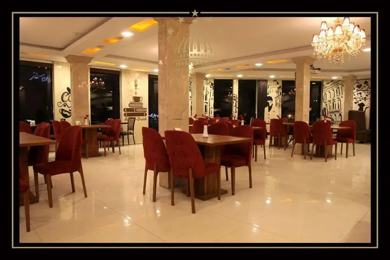 تصویری از دکوراسیون داخلی شیک و مدرن کافه و رستوران مجموعه پذیرایی خیام با نورپردازی گرم و مبلمان راحت.