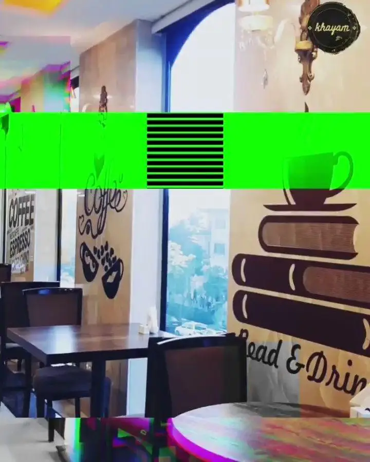 فضای داخلی جذاب مجموعه پذیرایی خیام، کافه‌ای دنج با میز و صندلی‌های راحت، دیزاین هنری با طرح‌های قهوه و کتاب "Read & Drink".