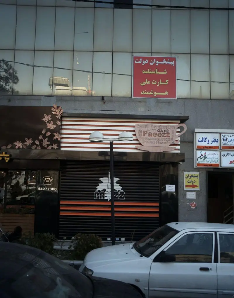 نمای بیرونی فست فود و کافه پاییز (Pae zzz)، واقع در یک ساختمان تجاری با شیشه‌های رفلکتیو و تابلوی پیشخوان دولت، در خیابان.
