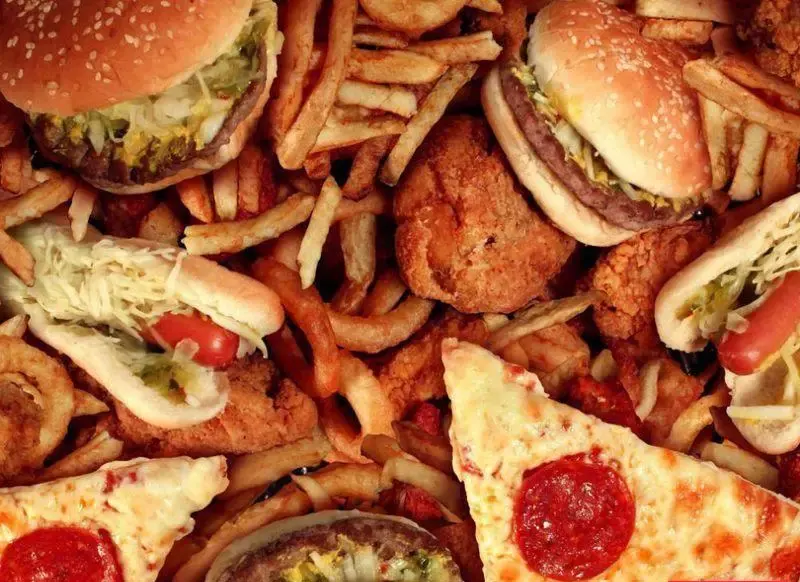 انواع فست فودهای خوشمزه و تازه شامل همبرگر، هات داگ، سیب زمینی سرخ کرده، پیتزا و مرغ سوخاری برای فست فود فان
