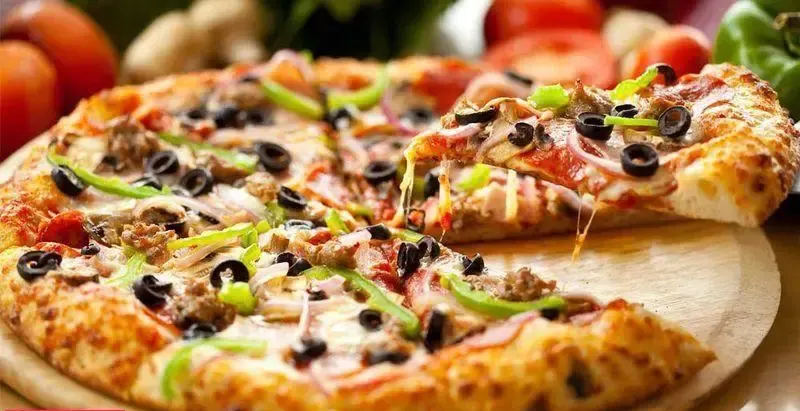 پیتزا تازه و داغ فست فود فان با تاپینگ‌های قارچ، زیتون سیاه، فلفل دلمه و گوشت چرخ‌کرده، همراه با پنیر کشدار آب شده و وسوسه‌کننده.