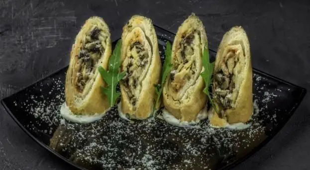 چهار رول قارچ و پنیر ایتالیایی خوشمزه، با سس و سبزیجات تازه، یک پیش‌غذای عالی از رستوران بونو. تجربه‌ای دلپذیر.