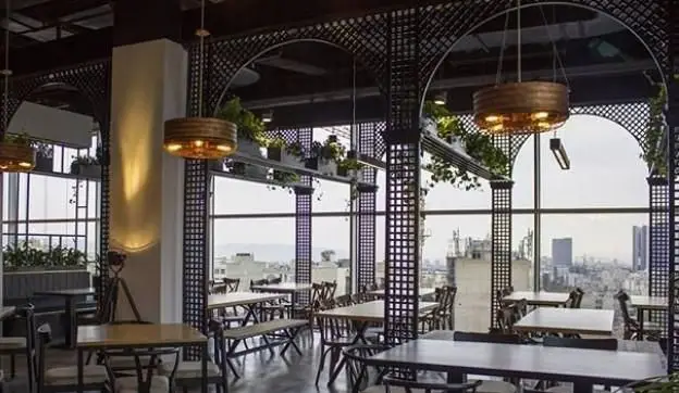 فضای داخلی دلباز و مدرن رستوران ایتالیایی بونو با پنجره‌های بزرگ، منظره چشم‌نواز شهر، دکوراسیون شیک و محیطی دلنشین برای صرف غذا.