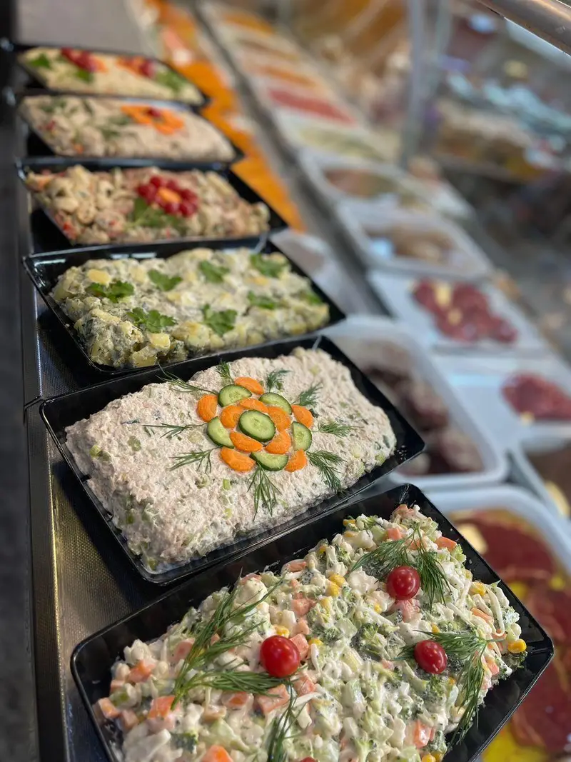 ویترین سوپر پروتئین ملل با انواع سالادهای تازه و آماده، شامل سالاد الویه، سالاد ماکارونی و سالاد سبزیجات برای فروش.