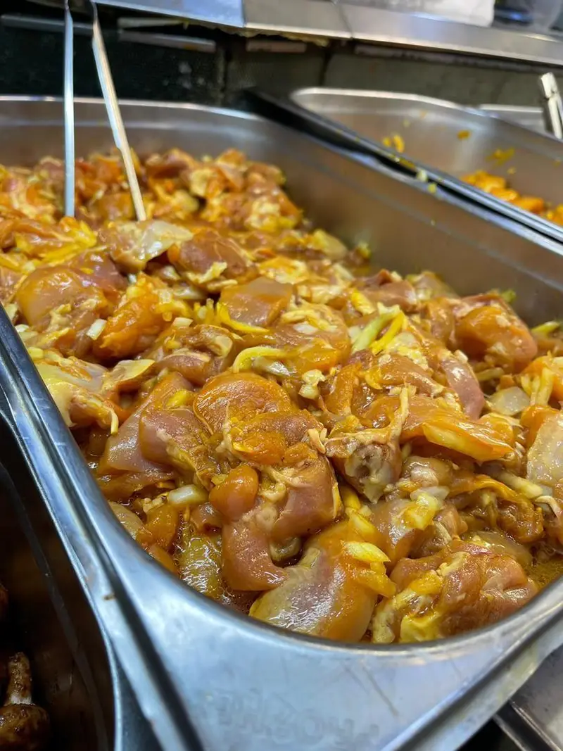 تصویری از مرغ طعم دار شده با پیاز و ادویه در سوپر پروتئین ملل، آماده برای تهیه جوجه کباب و انواع غذاهای پروتئینی خوشمزه و تازه.